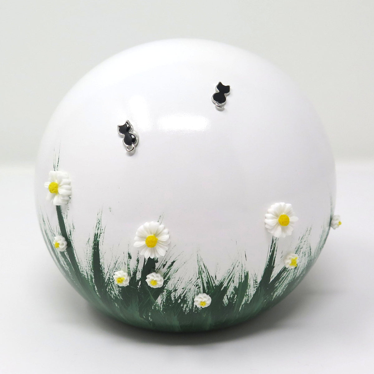 weiße tierurne in kugelform mit 3d applikationen die im dunkeln leuchten