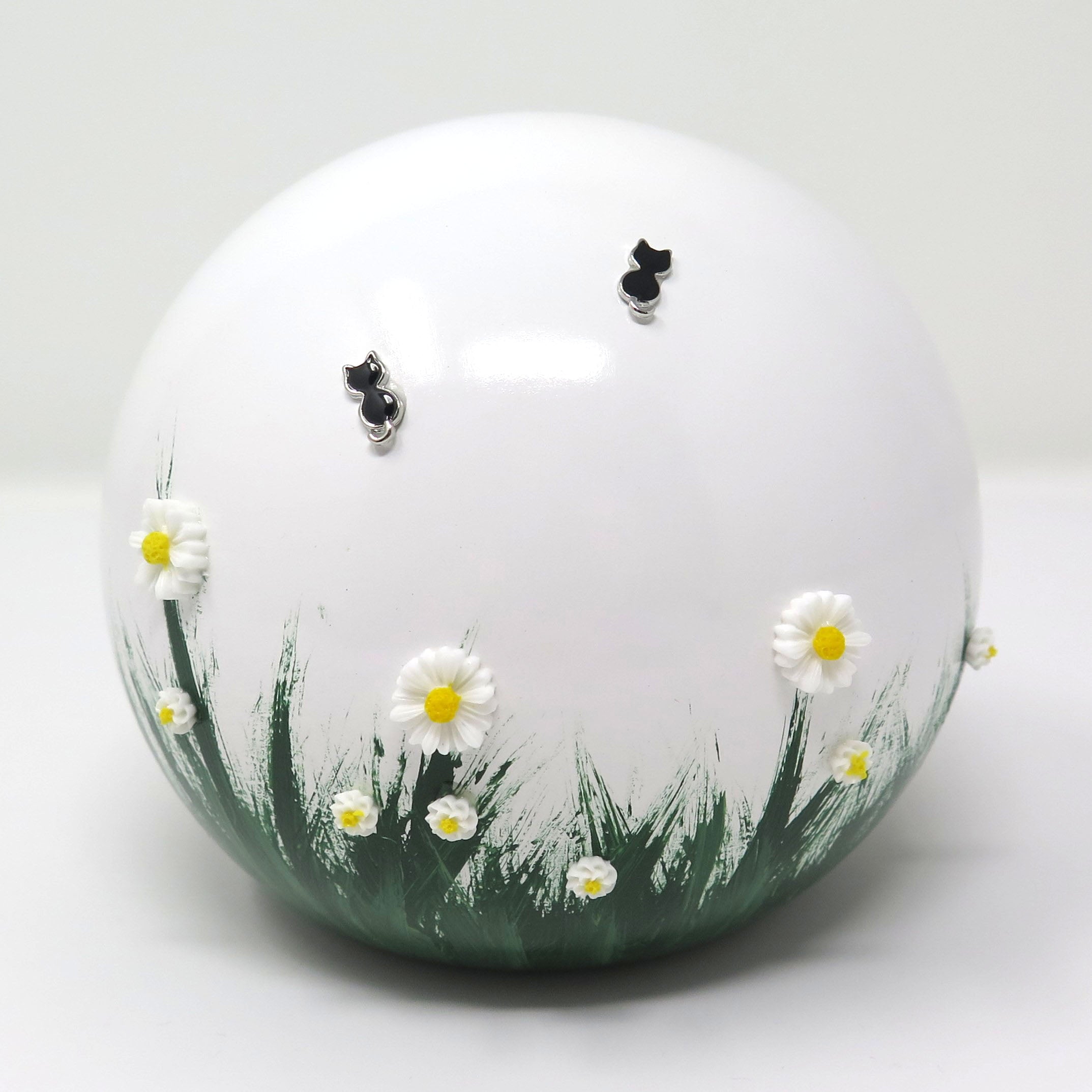 weiße tierurne in kugelform mit 3d applikationen die im dunkeln leuchten