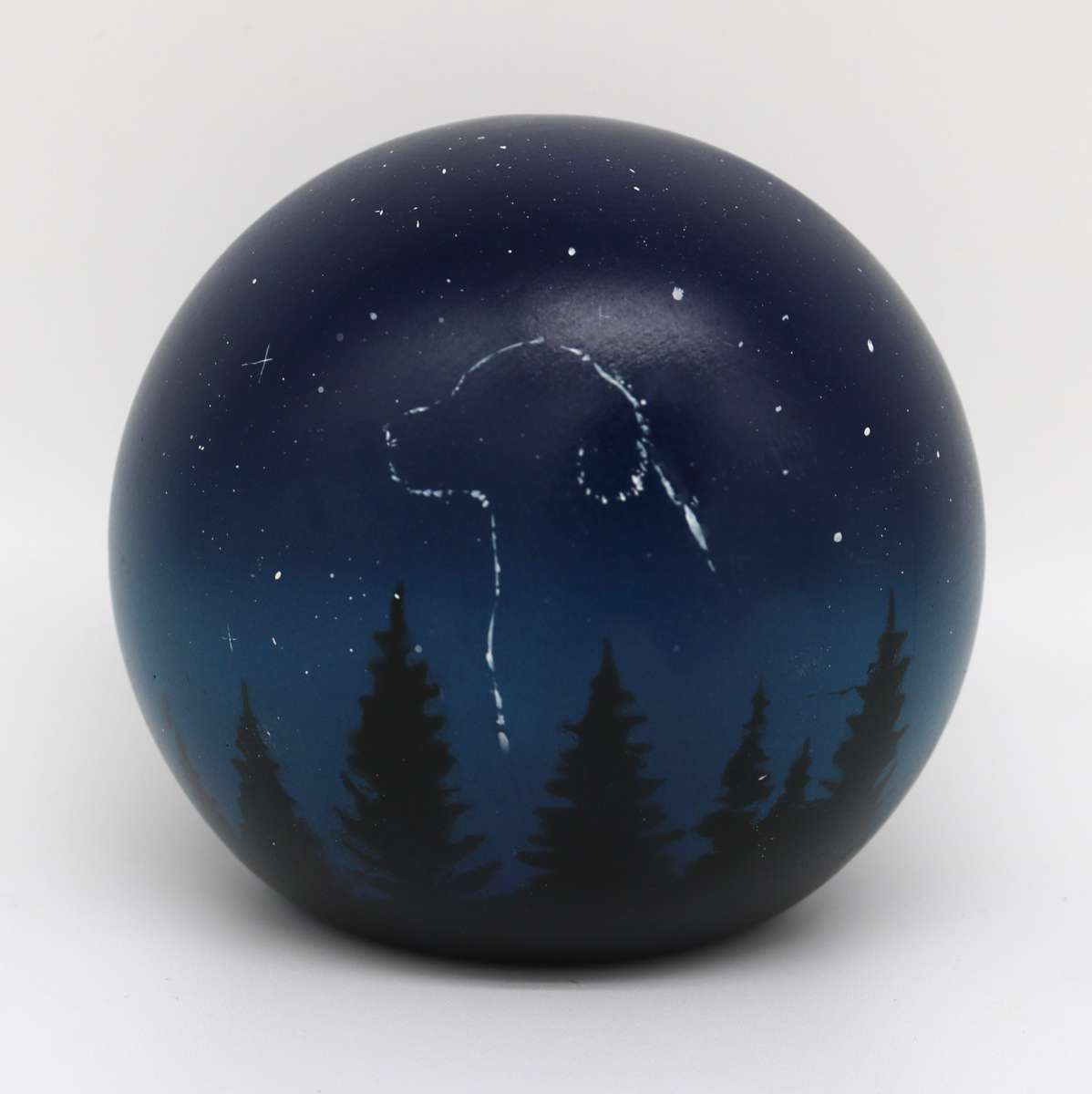 Dunkelblaue Urne in Kugelform mit Waldmotiv, Hundesilhouette und Sternen.