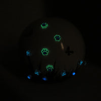 weiße tierurne in kugelform mit 3d applikationen die im dunkeln leuchten